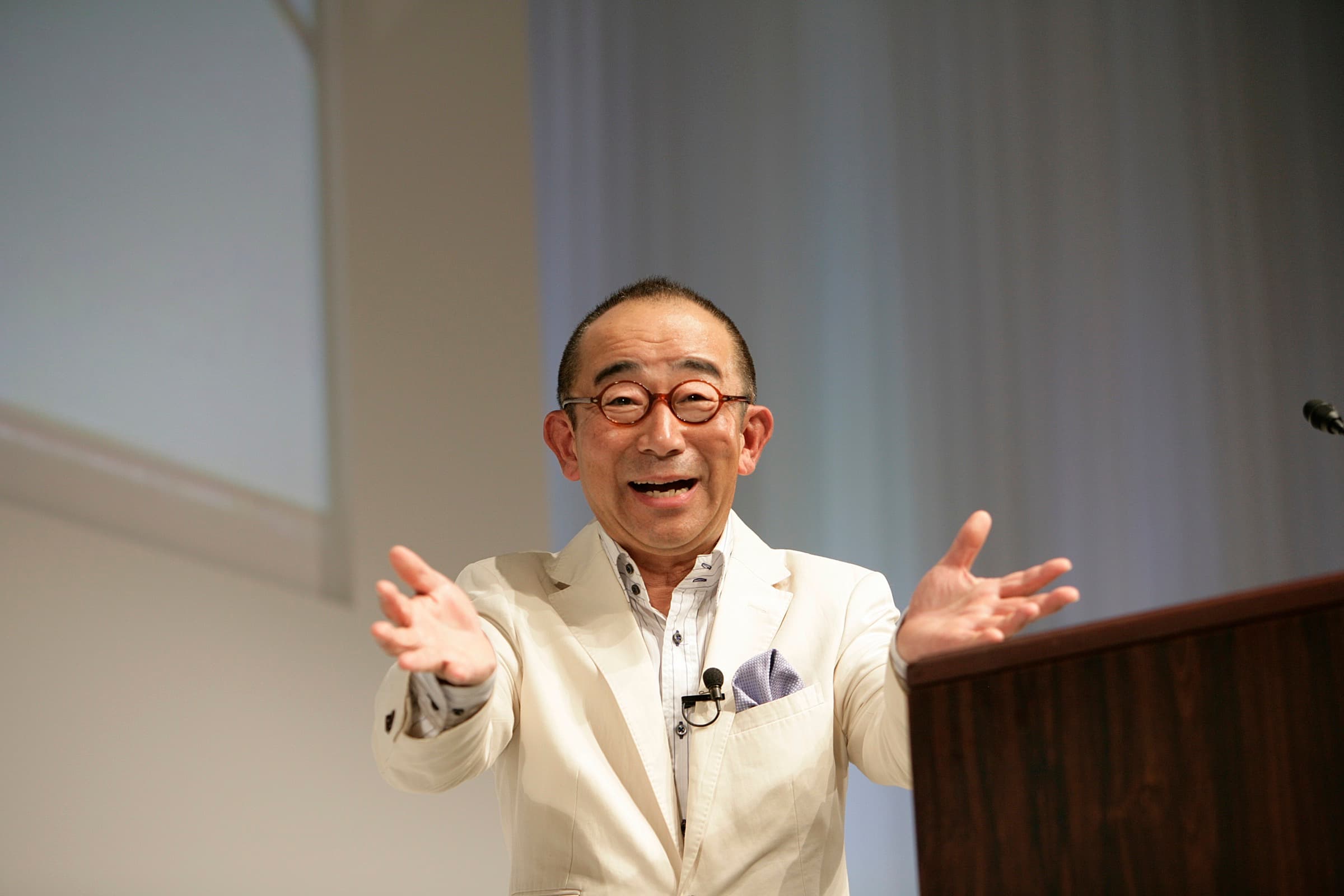 両手を広げて笑顔で語る門川義彦の講演